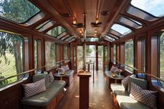 the inside of a train car with lots of windows and couches on it's sides