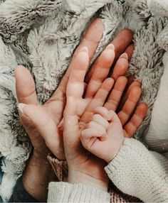 a person holding their hands up in the air with snow all around them on a blanket