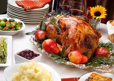 a large turkey sitting on top of a table next to other plates and bowls filled with food