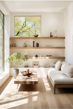 a living room filled with white furniture and wooden shelves on the wall next to a window