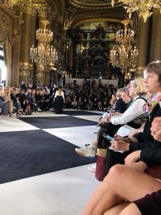 a group of people sitting on top of a black and white checkerboard floor