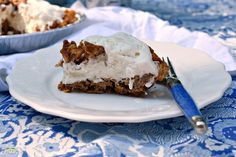 a piece of cake sitting on top of a white plate next to a blue and white table cloth