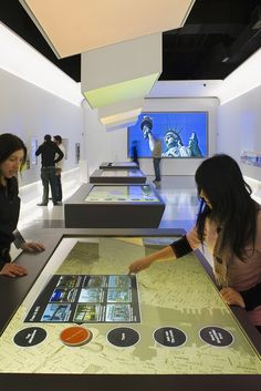 two women looking at pictures on display in a museum