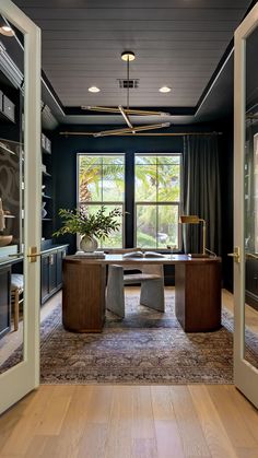 a living room filled with furniture and a large window covered in glass door frames next to a wooden floor