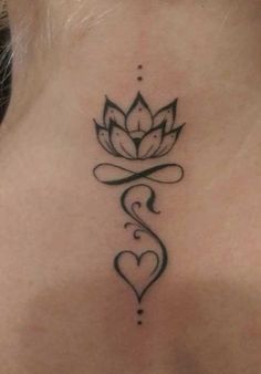 a woman's back neck with a lotus tattoo on the lower part of her neck