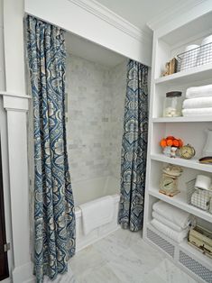 the bathroom is decorated in white with blue and orange decor on the shower curtain rod