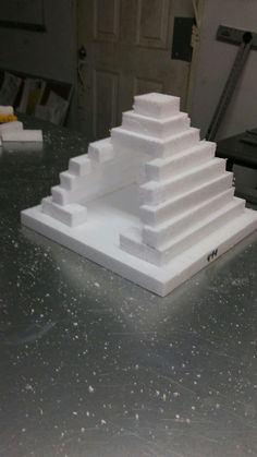 a white sculpture sitting on top of a metal table