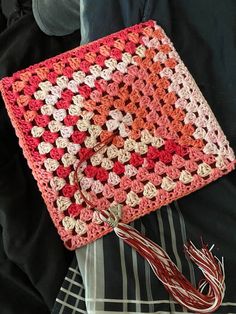 a crocheted square with a tassel hanging from it's end on a black jacket