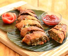 some food is laying out on a green leaf with sauces and ketchup