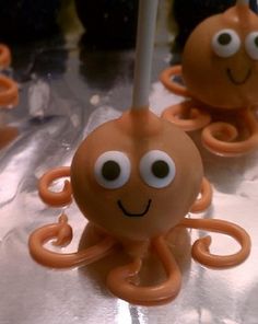 an octopus cake topper with googly eyes and two sticks sticking out of it's mouth