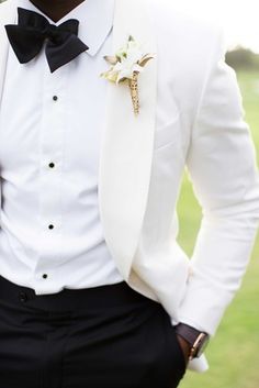 a man in a tuxedo is posing for the camera with his hands in his pockets