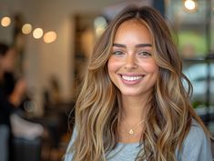 a woman with long hair smiling at the camera