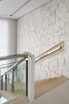 a white brick wall next to a metal handrail and glass balustncing