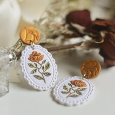 the earrings are decorated with flowers and leaves on them, along with other items from the collection