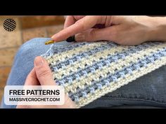 a woman is knitting on the side of a blanket with her hand holding a crochet hook