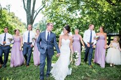 a bride and groom walking with their bridal party in the background at a wedding