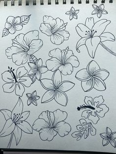 a drawing of flowers is shown on a sheet of paper with black marker pens in front of it