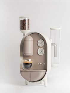 an automatic coffee maker with two cups on the top and one cup in the bottom