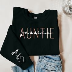 "Introducing our Personalized Auntie Sweatshirt - the perfect blend of warmth and sentimentality. This cozy sweatshirt is customized with the names of your beloved nieces and nephews, making it a heartwarming Gift for Aunt. Embrace your New Aunt status with pride, and let the sleeve tell a unique story with the special Kids' Names engraved. Elevate your auntie style with this personalized and meaningful apparel, combining comfort and cherished connections. Order now to showcase your Auntie Bliss in a fashion that's uniquely yours. Ideal for any situation, a unisex heavy blend crewneck sweatshirt is pure comfort. These garments are made from polyester and cotton. This combination helps designs come out looking fresh and beautiful. The collar is ribbed knit, so it retains its shape even afte Auntie Shirts For Nieces, Auntie Outfits, Aunt And Niece Shirts, Auntie Sweatshirt, Gifts For Aunts, Auntie Era, Aunt T Shirts, Gift For Aunt, Sweater Ideas