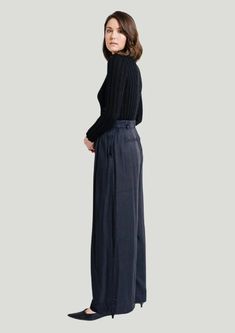 The Laude the Label Hepburn Pant is made of black satin and lined in 100% cotton. It features a high waist to extenuate your curves and a wide-leg flowy bottom for a comfortable style. The black color and ingenuous design make these pants perfect for a day at the office turned into a night on the town. To elevate your look, we recommend pairing it with a form-fitting top and heeled shoes. Form Fitting Tops, Posh Style, Flowy Fabric, Comfortable Style, Black Fits, Comfortable Fashion, Black Satin, Satin Fabric, The Label