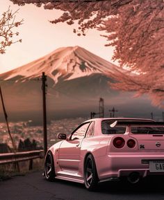 a pink car parked in front of a mountain