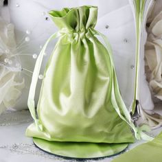 a green satin bag sitting on top of a table