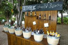 several buckets filled with beer sitting on top of a wooden table next to a sign