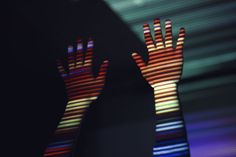 a person with their hands out in front of a blurry image of colorful lights