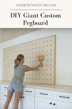 a woman using a paint brush to paint pegboard on the wall with text overlay that reads diy giant custom pegboard