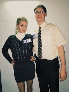 a man standing next to a woman in front of a white wall wearing a dress shirt and tie