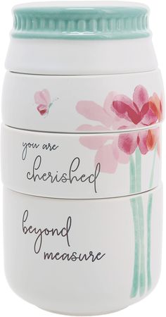 three ceramic containers with flowers painted on the sides and words written in black ink above them