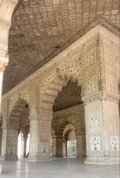 the interior of an ornate building with white walls and arches, decorated with intricate carvings