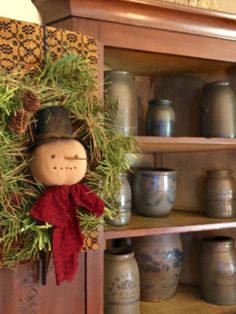 a christmas wreath with a snowman on it and pine cones in the bottom right corner