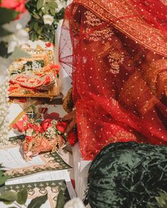 the table is covered with red and gold cloths, flowers, and other decorative items