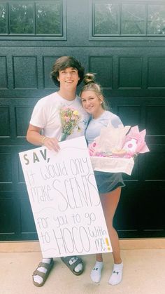 two people standing in front of a garage holding a sign that says sav could only make sents for you to go with flowers