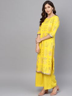 Look beautiful and polished in this yellow kurta set from Ahalyaa. The bright yellow soft kurta is adorned by a pop color ethnic print highlighted in gold. The suit is subtly highlighted by printed pleated fabric at the sleeve and kurta end. Sizing Tip: Please order a garment at least 2" More than your body measurements for the ease of wearing & taking off the garment. Product Features :   Color: Yellow Fabric: Viscose Rayon Pattern: Hand Printed Fit: Regular Sleeve: 3/4 Sleeve Neck: Boat Ne Designer Yellow Palazzo Set With Printed Motifs, Designer Yellow Kurta With Printed Motifs, Designer Wear Yellow Kurta With Printed Motifs, Yellow Chikankari Embroidery Palazzo Set For Eid, Yellow Anarkali Palazzo Set, Yellow Palazzo Set For Diwali, Yellow Anarkali Palazzo Set With Printed Motifs, Yellow Long Sleeve Palazzo Set With Chikankari Embroidery, Traditional Yellow Palazzo Set For Navratri