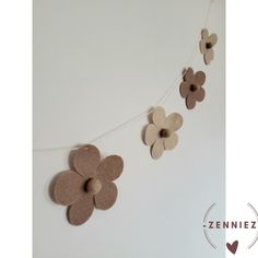 some felt flowers are hanging on a string