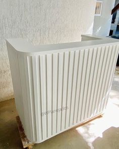 a white radiator sitting on top of a wooden pallet next to a building