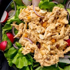 a salad with chicken, lettuce and radishes in it on a plate