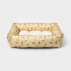 a dog bed that is made out of fabric and has dogs on the front, with two