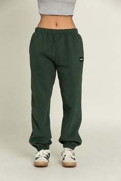 Elevate your athleisure style and feel like you're lounging on the go with our Hunter Green GH Jogger Sweatpants. The elastic waistband and tapered leg style allows you to feel secure and trendy. Complete with dual side pockets to keep your essentials close by. Pair with ur Hunter Green GH Cropped Hoodie to complete the set. Sporty Sweatpants With Elastic Cuffs For Streetwear, Sporty Relaxed Fit Pants For Loungewear, Casual Green Sweatpants With Elastic Side Panels, Athleisure Streetwear Joggers With Elastic Cuffs, Sporty Streetwear Joggers With Elastic Cuffs, Casual Green Pants With Elastic Side Panels, Athleisure Joggers With Elastic Cuffs For Streetwear, Sports Sweatpants With Tapered Leg And Elastic Cuffs, Sporty Sweatpants With Elastic Waistband For Loungewear