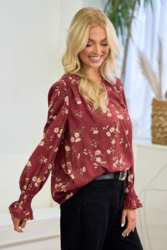 Doe & Rae Beautiful pale pink flowers print blouse with gold foil shiny accents in the center of the flowers. Smocked wrist and back for just the right amount of stretch and fit. Shown with front tucked in. So pretty! It's a must see in person.Color: Burgundy Sizes: S-M-L Bust 36-38-40, Length 26 100% Polyester, imported M2/41762T Daytime Floral Print V-neck Tops, Fall Floral Print Embroidered V-neck Top, Red Blouse With Floral Print And 3/4 Sleeve, Pale Pink Flowers, Stretch Floral Print V-neck Blouse, Red Floral Print Blouse With 3/4 Sleeves, Smocked Blouse, Flower Print Blouse, Front Tuck