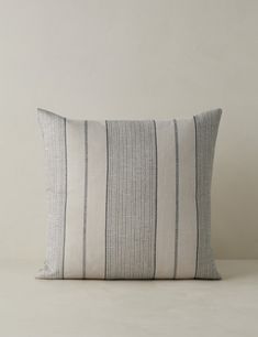 a gray and white striped pillow sitting on top of a table