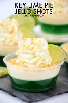 key lime pie jello shots in small plastic cups with limes on the side