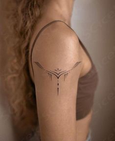 a woman's arm with a tattoo on it that has an arrow in the middle