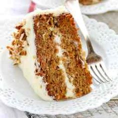 a slice of carrot cake on a white plate with a red border around the edge