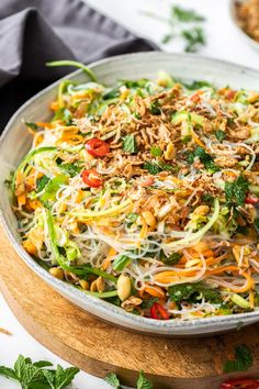 a salad in a bowl on top of a wooden cutting board