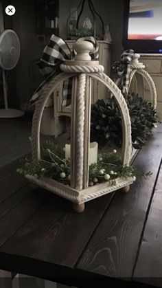 a white birdcage sitting on top of a wooden table