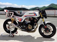 a white motorcycle parked on top of a parking lot next to a mountain range with mountains in the background