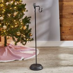 a christmas tree with an umbrella stand in front of it and a pink blanket on the floor